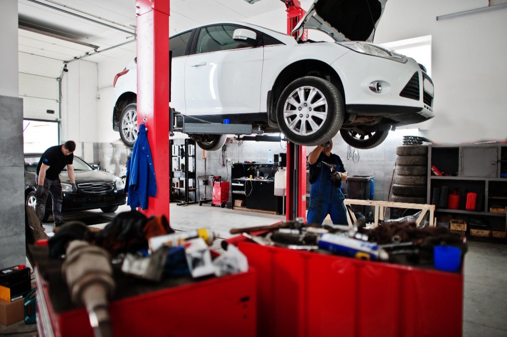 A car up on the hoist in a tyre and mechanical workshop